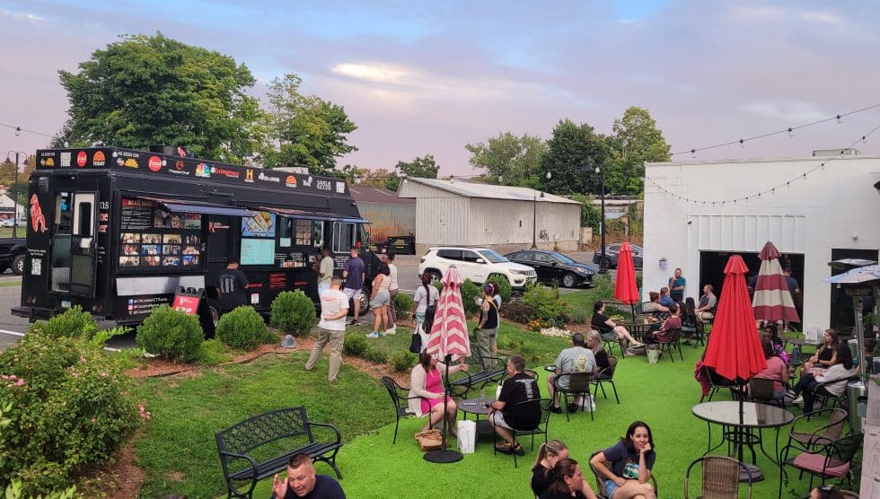 Residents enjoy lobster from food truck Cousins Maine Lobster while attending the July 25 informal talking session about the possibilty of creating a center town district.